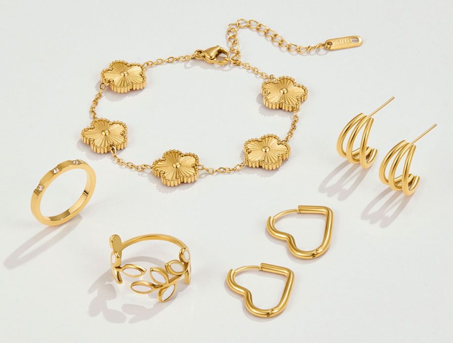 14-Jewelry - Style Fix Studio Gold jewelry set including a flower-link bracelet, two heart-shaped hoop earrings, a floral ring, a leaf-inspired ring, and spiral hoop earrings in a warm gold tone