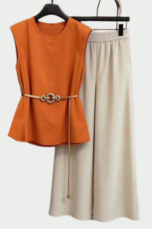 Wardrobe - Style Fix Studio Orange sleeveless peplum top with a tan belt worn over beige wide-leg pants on hangers.